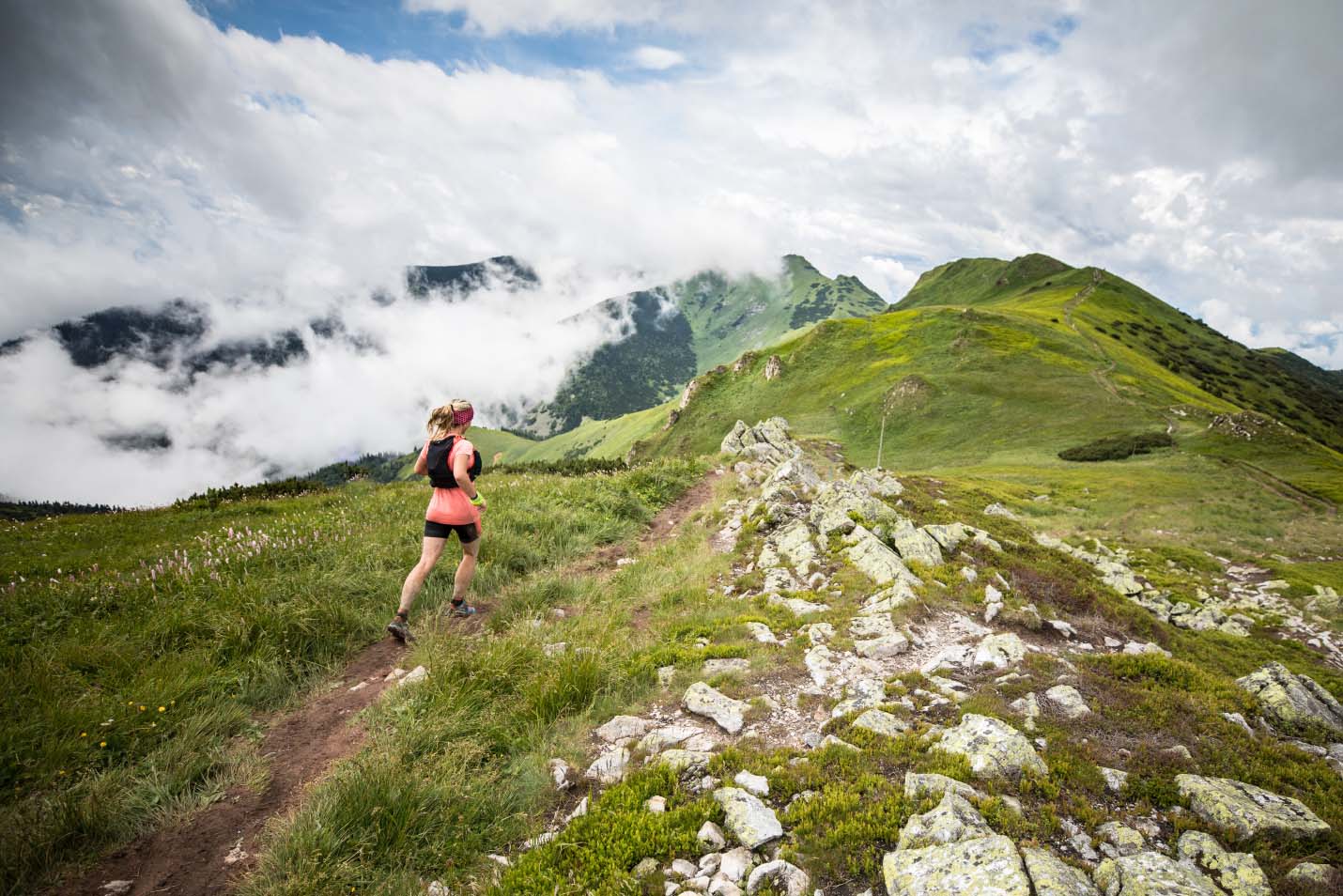 woman running on top of the mountains, cloudy day